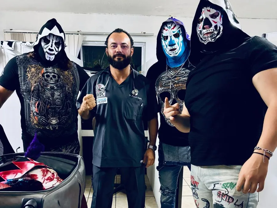 El Dr. Grimaldo con luchadores enmascarados antes de un evento