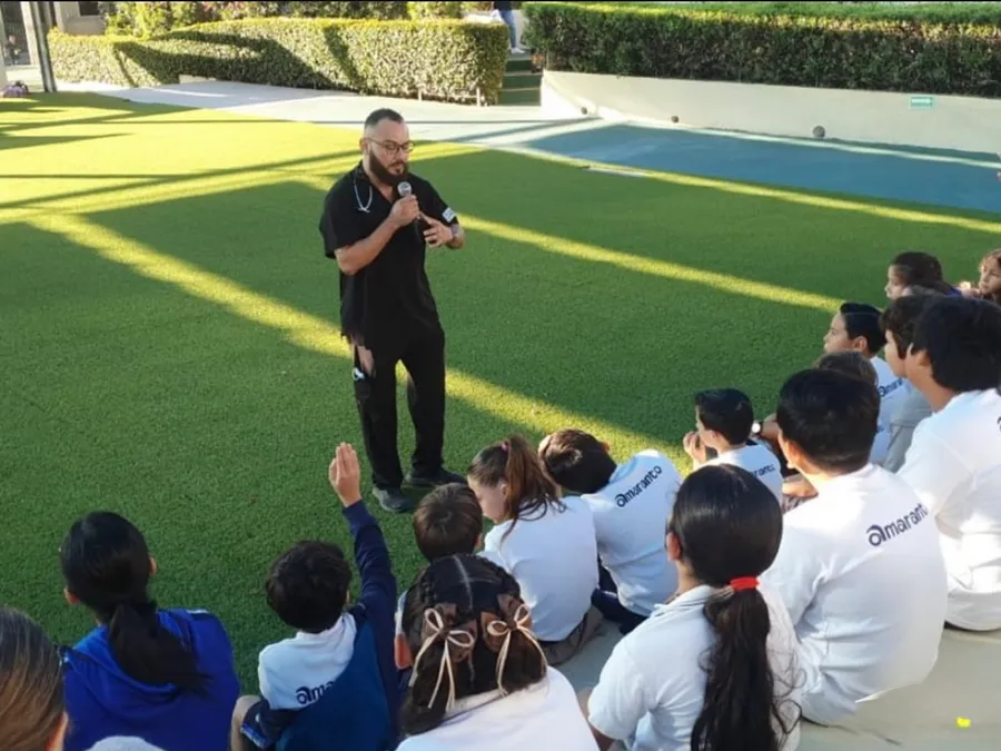 Instructor dirigiéndose a un grupo numeroso de alumnos en la cancha de una escuela de Los Cabos